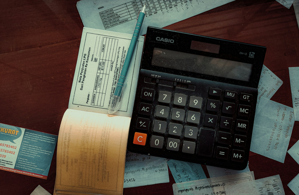 A table with a balancing book, check book and calculator